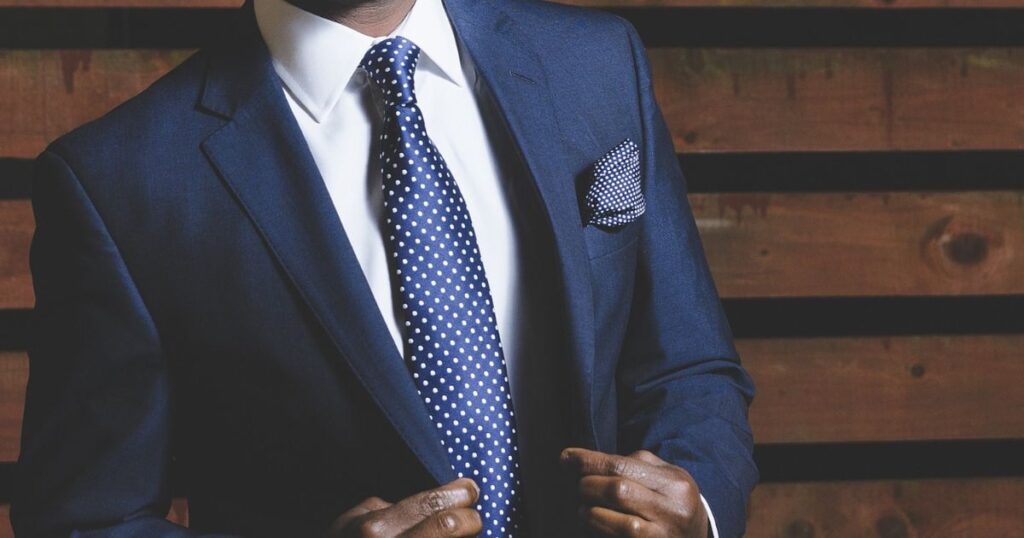 A man in a blue suit and tie, exemplifying elegance and professionalism, showcasing what style suits you the best.