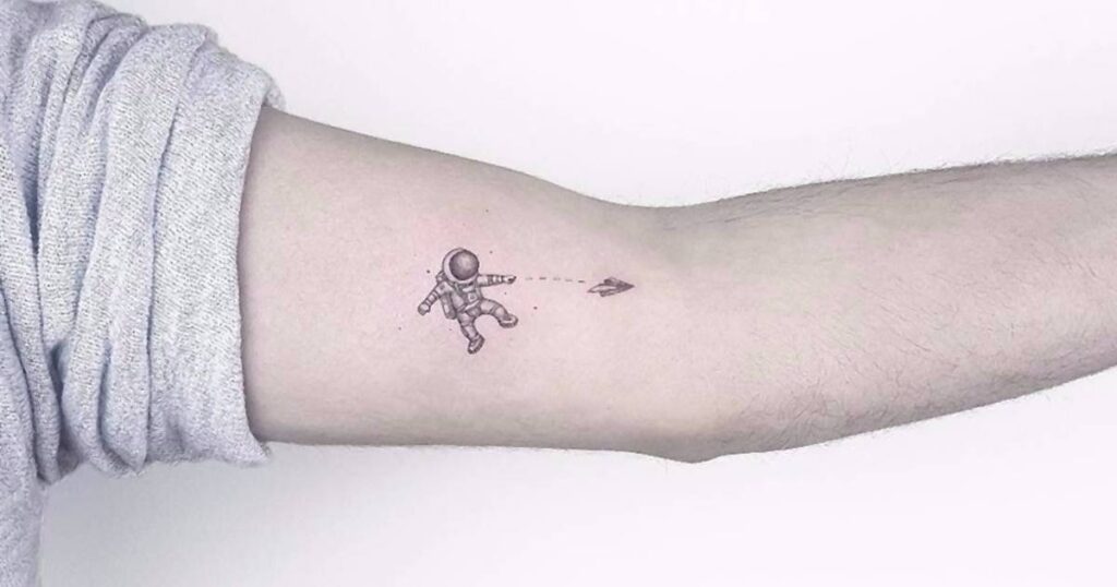 A small tattoo depicting a man flying a kite, symbolizing freedom in "Crafting Your Vine Tattoo: A Natural Art Form."